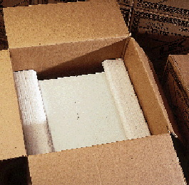 An operator packs L-shaped inserts into a case (above) prior to shipping. Besides improving its cushioning (opposite right and