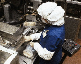 Blister packs and lidded cups are two prominent techniques for providing single-dose packs of medication. A worker at Packaging