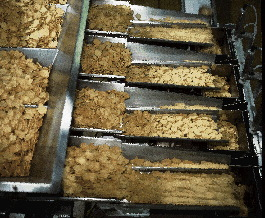 Product is automatically fed into canisters by a PLC-controlled four-bucket filler (above). Product reaches the four individual