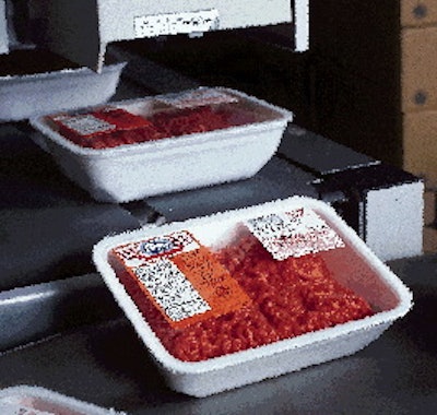 Near the end of the automated ground beef packaging line are two blow-down p-s labelers. The first (right) applies a label car