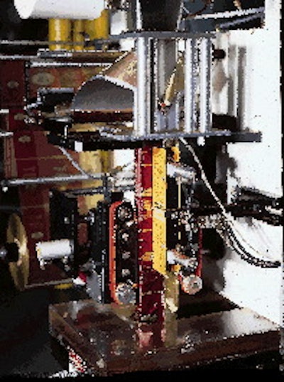 The paper filter unwind and bagging unit are shown close-up (left), while the overwrapping station appears above. Finished ov