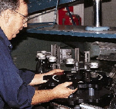 This close-up shows the starwheels and center guide for an air cleaner at Seagram?s LaSalle plant. Located on the center guide i