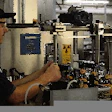 A line operator looks at beer bottles as they pass the second inspector on the line. This unit checks for label placement and ma