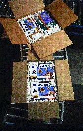 By squeezing a scissors valve on a downspout, an operator releases loose fill into a shippper. 3Com products (inset) are surrou