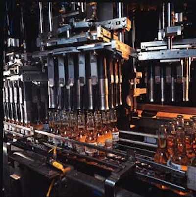 As a group of bottles is conveyed right to left in the case packer, one of the eight heads of gripping bells moves into position