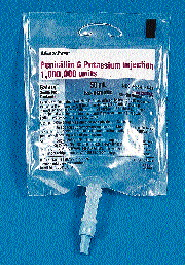Filled bags of pre-mix antibiotics (such as the one at left) convey to a manual inspection station (above) where production asso