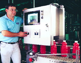 Steve Daniels checks the vision system as filled and capped bottles index to a downstream cooler