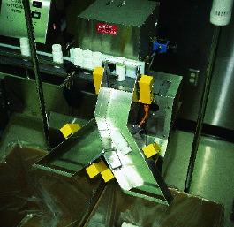 A custom bottle count verifier uses a burst of air to blow bottles down a Y-shaped chute equipped with multiple light curtains