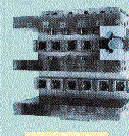 In the foreground are 12 freshly blown bottles waiting to be discharged by pickoff-pins. Visible in the background are 12 prefor