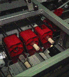 Automated bottle remover turns pucks over on their sides to allow a rod to push through a hole in the bottom of the puck and s