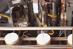As labels unwind from the roll, they pass through a perforation wheel, followed by a series of tensioning rollers that compensat