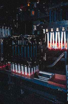 Each arm of the packer (right) includes a set of white finger guides for positioning and a black lowering head that picks up