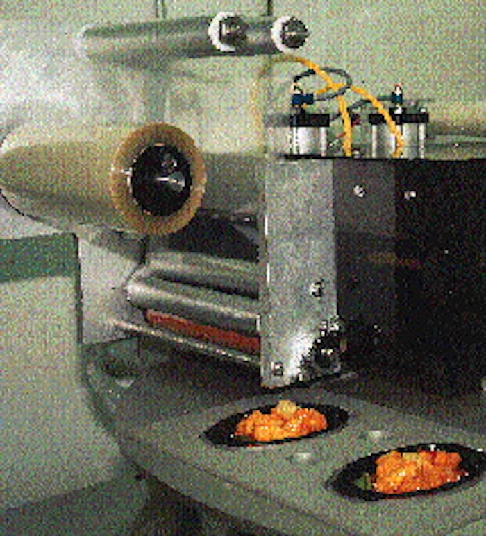 After filling, trays are evacuated, backflushed and lidded two-up on a rotary system. Then they1re loaded onto wheeled racks and