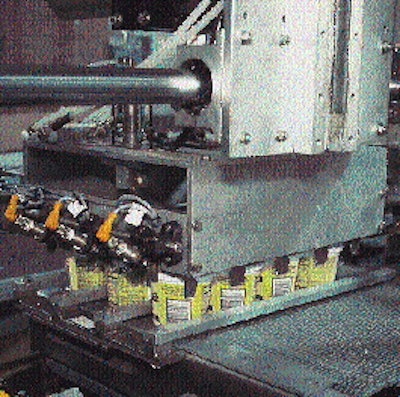 Reciprocating pickup head mechanically grips a case load of cups (left) and delivers them to a waiting case blank (above