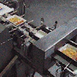 Filled trays pass through metal detection (lower right) and then a checkweigher (upper left