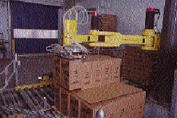 A robotic arm (top) transfers two of the heavy cases from the conveyor and onto a pallet load. The robot will soon be building t