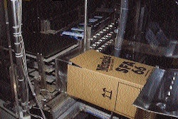 With a case erected and waiting, the packer pushes 12 cartridges into the box before it is transferred back to the line for seal