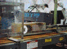 At the end of Barber Foods? packaging line, Lock?n?Pop is applied to a box top by two pneumatically operated nozzles