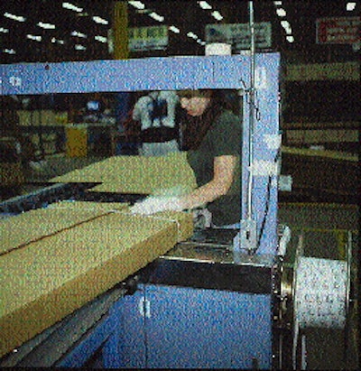 With one strap already in place (top), the operator holds down the flaps as a second strap is applied. Because the corrugated co