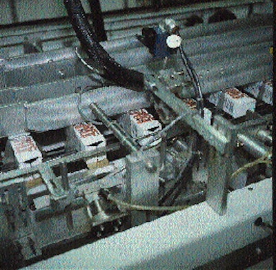 Two picking arms, each equipped with seven vacuum cups, rotate to pick carton blanks from the magazine feed and place them in
