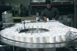 CREATING ORDER. One project, for a powdered household cleanser, begins on APCO Packaging's U-shaped packaging line with manual d