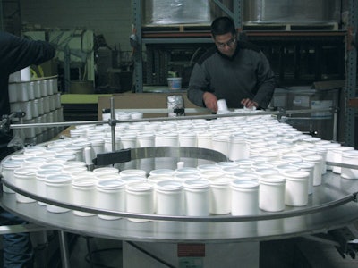CREATING ORDER. One project, for a powdered household cleanser, begins on APCO Packaging's U-shaped packaging line with manual d