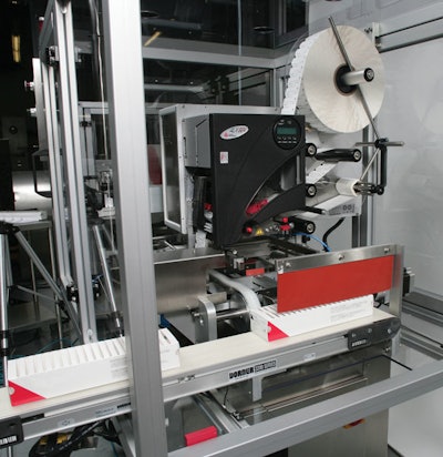TRAY LABELING. Freshly erected paperboard trays move through this thermal-transfer labeler, which prints variable information su