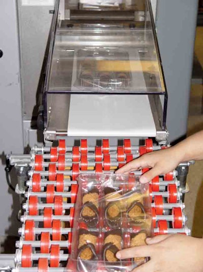 PROTECTIVE PACKAGING. The servo-driven wrapper (above) surrounds each 6-count cannoli shell tray with extrusion-laminated COPP f
