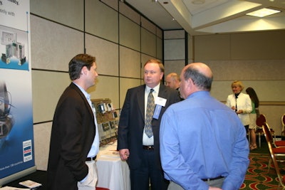 Brad Neuroth of Wyeth (center) visits Jeff Brown (left) and John Kowal (right) of event co-sponsor ELAU at their exhibit on stan