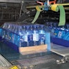 LANE COMBINING. Printed film is applied in register (above) to a 24-count tray of bottles. Three lanes of freshly blown bottles
