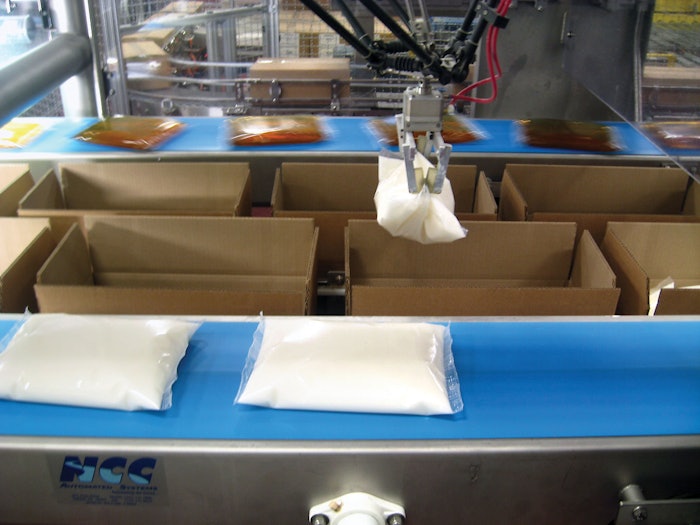 End-of-arm pouch-picking tools use fingers covered in hardened rubber to grab a pouch and lift it into a case.