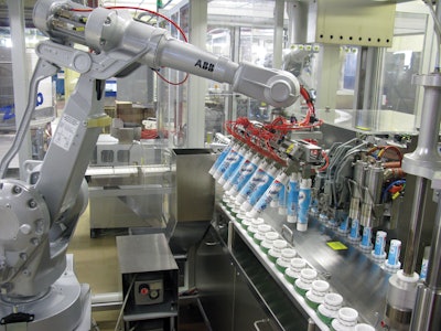 Empty tubes are picked from boxes by the robot’s twin-row end effector and placed in the filler’s pucks.