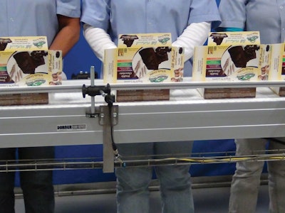 Set-up cartons proceed to the hand-load conveyor for gentle, manual top-loading of baked goods.