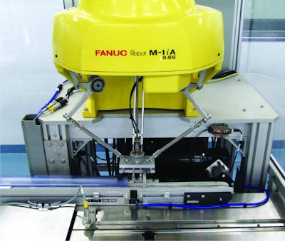 A high-speed delta robot uses a vacuum end-of-arm tool to pick up individual diagnostic test kits and feed them to a flow wrapper.