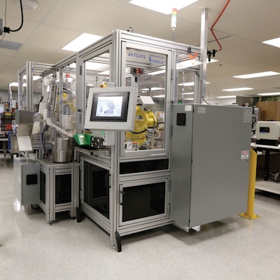 FRONT VIEW. The front of the AFTCATS robotic bottling system shows the main touchscreen display, with the pick-and-place loading robot shown in the window.