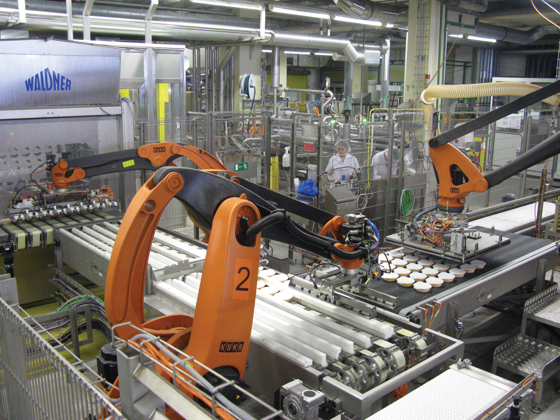 MULTIPLE ROBOTS. Photo shows how robots one, two, and three automatically move lidded plates to the retort crates.