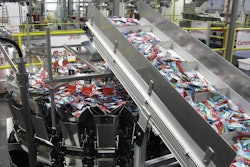 BAGGER, CARTONER. Pouches of fruit snacks move through a combination scale.