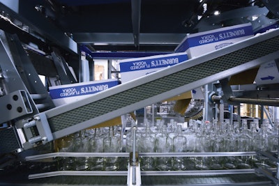 REMOVING RESHIPPERS. Arriving at the Heaven Hill plant in corrugated reshippers, the glass bottles are fed into the filling line by this automated uncaser.