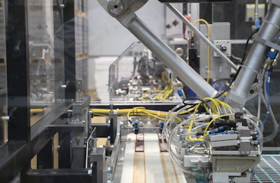 A two-axis robot uses vacuum pickup to transfer Neapolitans from the counter molds and place them on the infeed belt of the packaging machines.