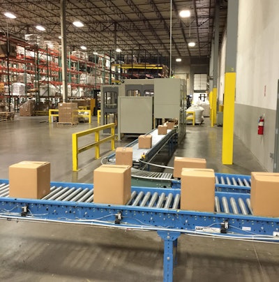 Filled/sealed shipping cases are roller-conveyed to the palletizing station.