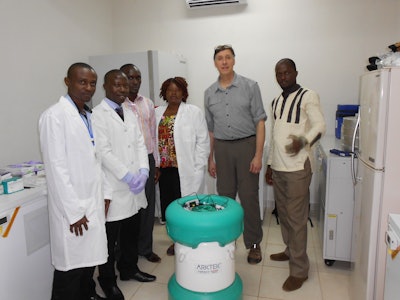 Geoffrey Glauser poses with officials from the College of Medical and Health Sciences and an Arktek container.