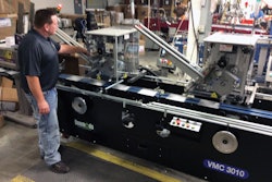 Packaging Supervisor Matthew Gackstetter observes the pick and place affixing process at the vacuum transfer table.