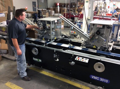 Packaging Supervisor Matthew Gackstetter observes the pick and place affixing process at the vacuum transfer table.