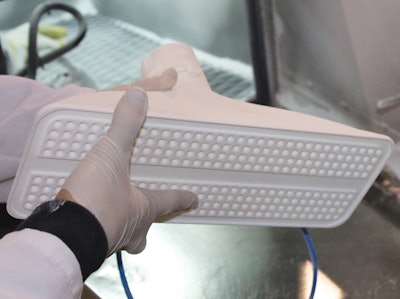 The end-of-arm tool has a Swiss cheese pattern of channels that would have been impossible to make using conventional machining techniques but was easy to accomplish with additive manufacturing.