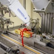 At Esther Price Candies, a six-axis robot with controller ties ribbons around candy boxes and forms bows at 2 boxes/min.
