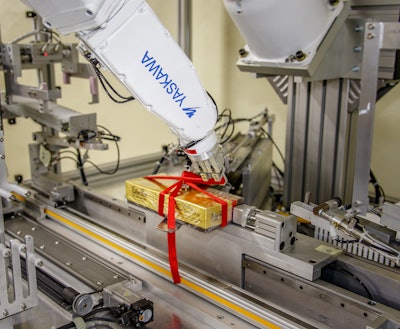 At Esther Price Candies, a six-axis robot with controller ties ribbons around candy boxes and forms bows at 2 boxes/min.