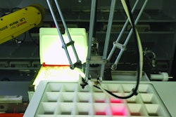 During tray filling, pills are dispensed by a robot through a grid that uses laser beams to verify correct pill placement.