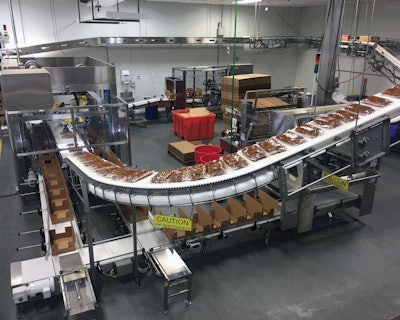 Photo A--The fully automated case packing operation—case erector, robotic case loader, and case closer.