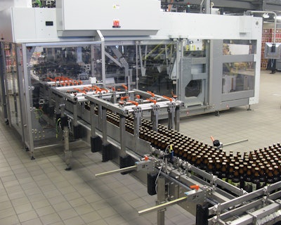 Shortly after freshly filled bottles enter the Varioline packing system, they’re picked and placed into cases that have six-pack paperboard carriers already in them.