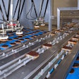 Two Venturi-based end effectors per robot gently pick the rusk slices and place them into the infeed chain of the tray loader.